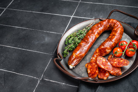 Sliced Chorizo sausage, slices of dry cured pork with herbs and spices. Black background. Top view. Copy space.の写真素材
