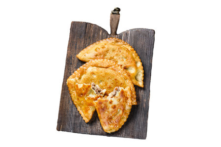 Chilean fried empanadas filled with minced beef meat served on a wooden cutting board. Isolated on white background, top viewの写真素材