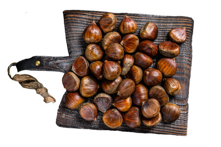 Raw chestnuts on a wooden cutting board. Isolated on white background, top view.の写真素材
