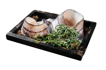 Raw Haddock fish fillets in wooden tray with rosemary and thyme. Isolated on white background. Top...
