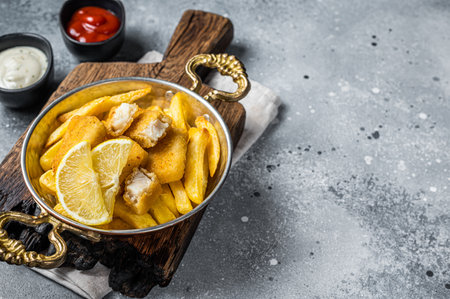 Fish fingers and Chips british fast food with tartar and tomato sauce, seafood sticks. Gray background. Top view. Copy spaceの写真素材