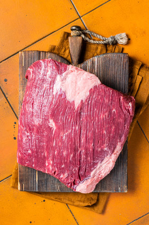 Whole piece of raw Beef Brisket meat. Orange background. Top view.の写真素材