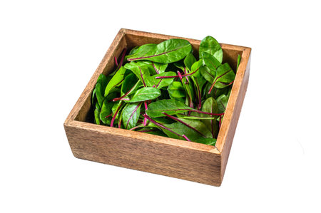 Raw Fresh green chard mangold leaves in a wooden box. Isolated on white background. Top view