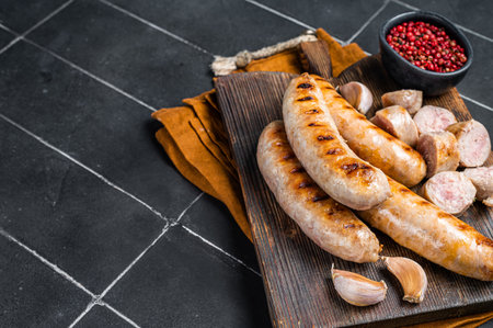 German grilled Bratwurst pork meat sausages on a wooden board. Wooden background. Top view. Copy space.の写真素材