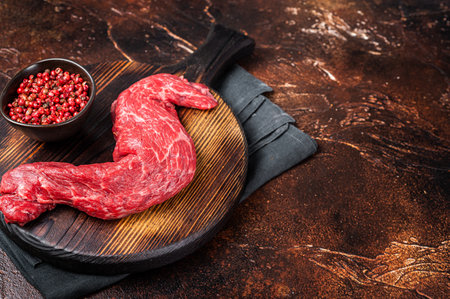 Raw Skirt Machete beef meat steak on wooden board. Dark background. Top view. Copy space.の写真素材