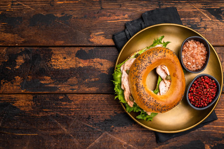 Fresh cooked Bagel with smoked salmon, lettuce and cream cheese in a plate. wooden background. top view.の写真素材