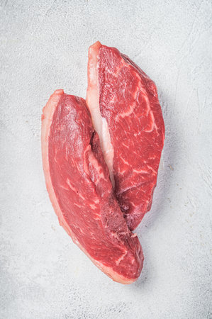 Raw top sirloin steak, cap rump beef meat steak. White background. Top view.の写真素材