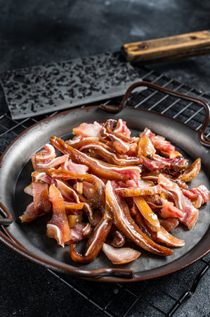 Traditional gourmet smoked pork pig ears. Black background. Top view.の写真素材