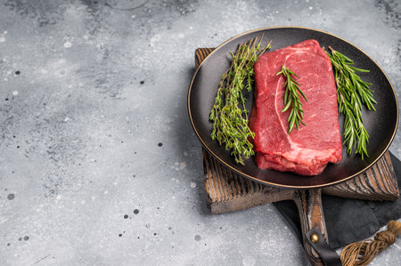 Raw Top sirloin beef steak with herbs. wooden background. top view.の写真素材