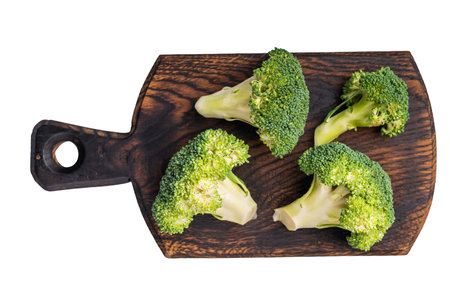 Fresh raw broccoli pieces on a wooden board isolated on white background. top view.の写真素材