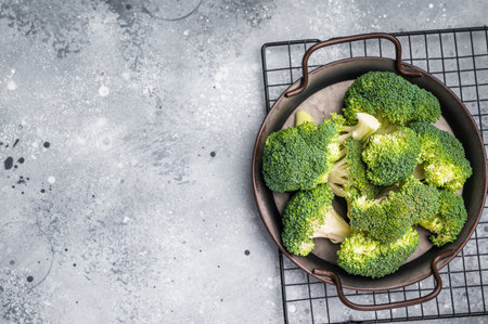 Green fresh broccoli pieces in a steel tray. gray background. top view.の写真素材