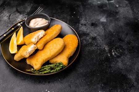 Crispy fried cod Fish sticks on plate. black background. top view.の写真素材