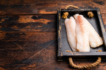 Fresh fish meat, Raw cod loin pieces without skin in wooden tray. wooden background. top view.