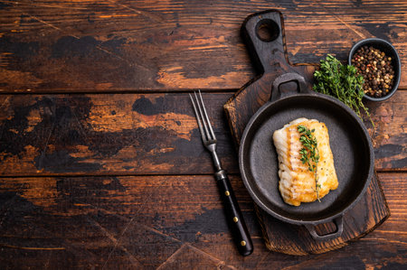 Roasted cod fish loin fiilet in skillet. Wooden background. top view.の写真素材