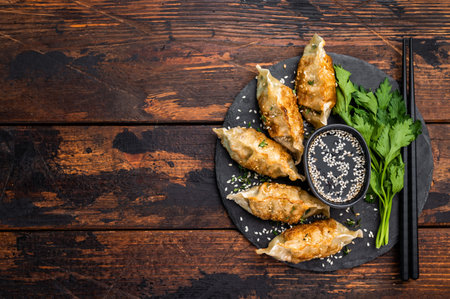 Fried Gyoza on plate with sauce, Japanese Dumplings with shrimps and vegetables. wooden background. top view.の写真素材