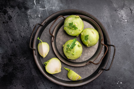 Raw kohlrabi on steel tray, Vegetable from Organic farm. black background top view.の写真素材