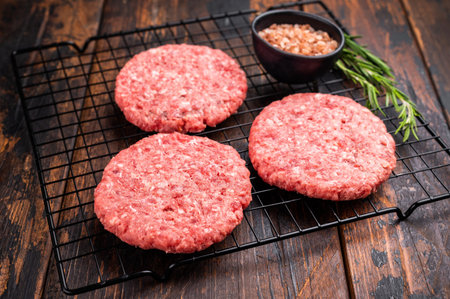 Raw meat patties, cutlets, chopped meat for burgers. wooden background. top view.の写真素材