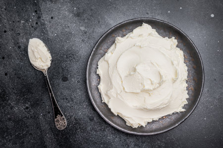 Creamy Homemade Mascarpone cheese, cream cheese. black background. top view.の写真素材