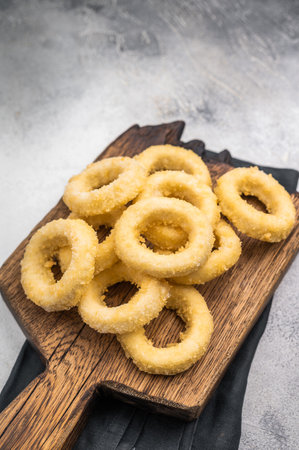 Raw and frozen squid rings with breading, uncooked calamari snack. white background. top view.の写真素材