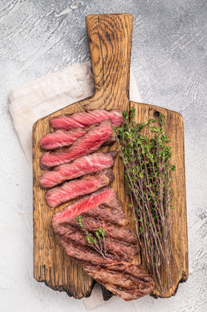Flavorsome beef shoulder tender, grilled in BBQ to juicy perfection, served with fresh herbs. gray background. top view.の写真素材