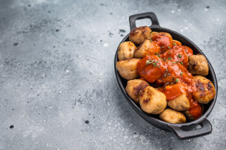 Roast meatballs served with tomato sauce. A classic comfort food in a skillet. gray background. top view.の写真素材