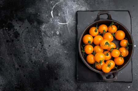 Fresh small yellow tomatoes, cherry tomatoes assortment, cocktail mix. black background. top view.の写真素材