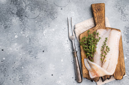 Fresh cod fish fillet, showing its delicate texture and pristine color, perfect for grilling or baking. gray background. top view.の写真素材