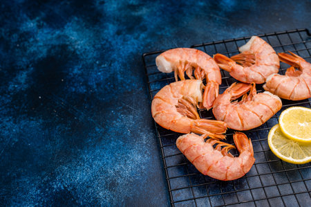 Ready for cooking Red shrimps, raw Prawns on a rack. blue background. top view.の写真素材