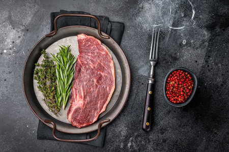 Prime raw top sirloin steak, highlighting its juicy texture and natural juices. Perfect for roasting or quick cooking on high heat. black background. top view.の写真素材
