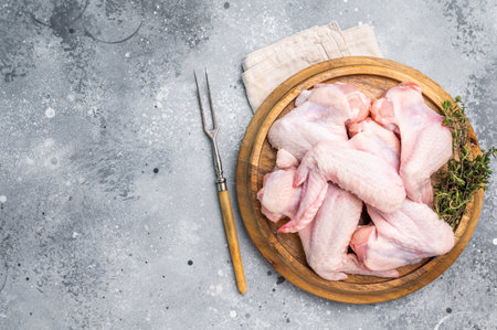 Fresh raw chicken wings, perfect for marinating and grilling, ready to become the star of your next barbecue. grey background. top view.の写真素材
