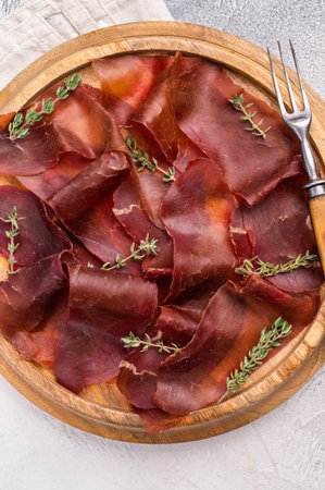 Cecina meat slices, spanish beef jamon on wooden tray white background. top view.の写真素材