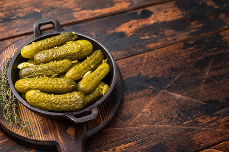Artisan Pickled Gherkins, pickled cucumbers, beautifully arranged and ready to elevate your culinary creations with their bold taste. wooden background. top view.の写真素材
