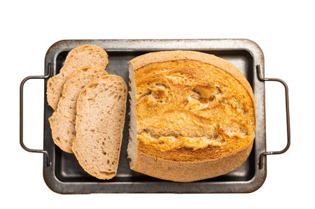Handcrafted sliced bread on kitchen tray isolated on white background. Top view.