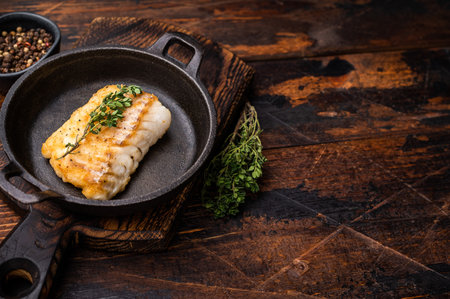 Roasted cod fish loin fiilet in skillet. Wooden background. top view.の写真素材