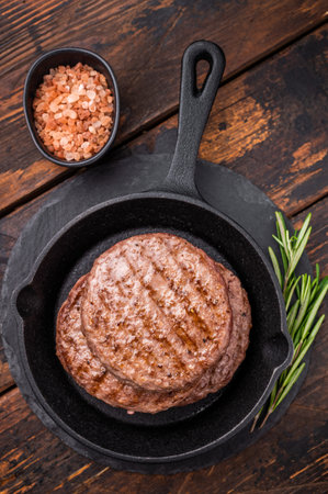 Deliciously charred grilled meat burger patty on the grill, perfect for satisfying cravings at any cookout. wooden background. top view.の写真素材