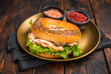 Fresh cooked Bagel with smoked salmon, lettuce and cream cheese in a plate. wooden background. top view.の写真素材