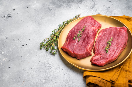 Raw Venison steak, fresh Wild Roe Deer Game Meat. gray background. top view.の写真素材