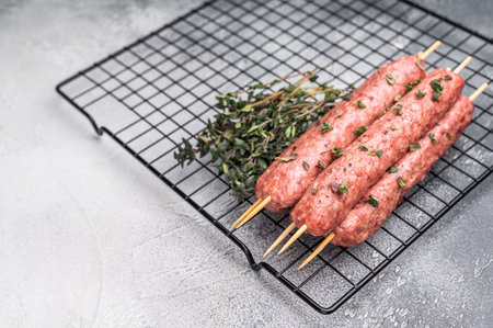 Raw kofta or lula kebabs skewers from mince lamb and beef meat on Skewer. gray background. top view.の写真素材