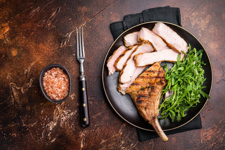 Succulent grilled Tomahawk pork chop, rib bone in steak featuring crispy edges and juicy meat that will tantalize your taste buds. brown background. top viewの写真素材