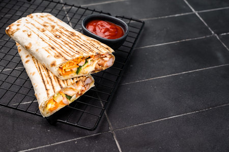 Turkish Shawarma, doner wrap sandwich with meat and salad. black background. top view.
