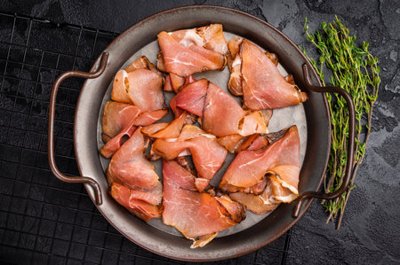 Italian Cured Prosciutto crudo ham. black background. top view.