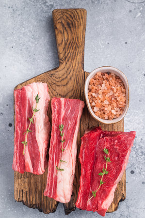 Raw meat composition. Fresh beef for grilling with herbs and vintage cutlery. Excellent copy space for textの写真素材