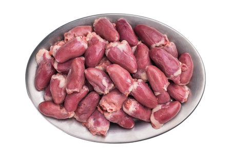 Close-up of raw poultry hearts in a metallic dish, pristine white background accentuates the meatの写真素材