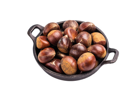 Raw chestnuts in rustic skillet ready for cooking isolated on white background.の写真素材