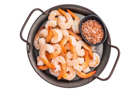 A tray of shrimp is served with a black bowl of salt.の写真素材