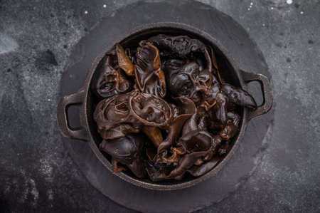 A bowl of fresh wood ear mushrooms, perfect for health conscious cooks seeking nutritious and flavorful ingredient. black background. top view.の写真素材