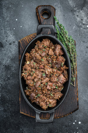 Slow cooked kawurma with shredded and diced beef chunks highlighting protein breakdown, caramelized surfaces and rustic ironpan presentationの写真素材