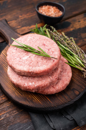 Uncooked beef and pork meat patty on a wooden board. wooden background. top view.の写真素材