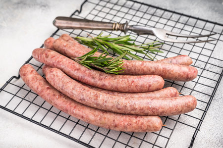 Fresh raw sausage links ready for grilling, perfect for barbecues or hearty family meals..white background. top view.の写真素材