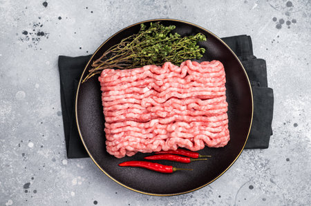 Raw mince beef meat, fresh mincemeat in plate. grey background. top view.